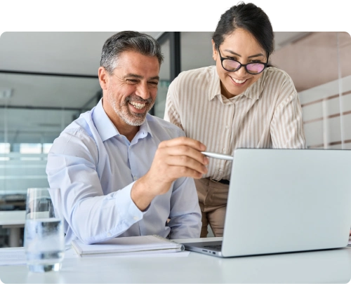 Homem e mulher sorrindo e apontando para o notebook