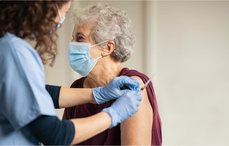 Idosa recebendo medicação contra a covid 19