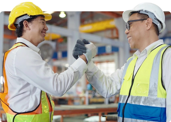 Homens parceiros do setor industrial segurando a mão um do outro e sorrindo